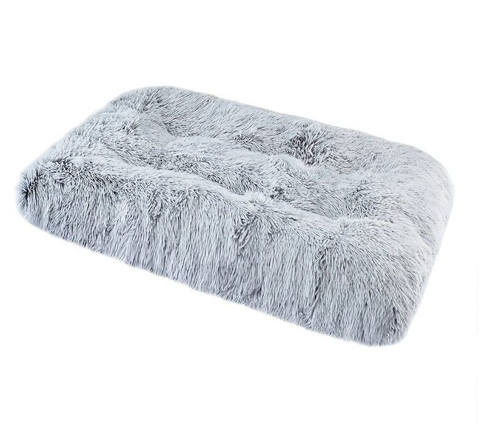 Grijs pluche hondenbed met antislip bodem in een ruime bench, geschikt voor grote honden.