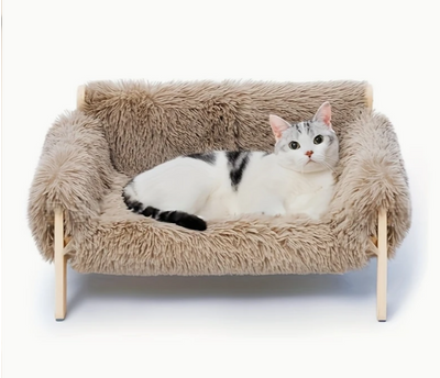 De verhoogde houten sofa met zacht, beige kussen voor kleine huisdieren.