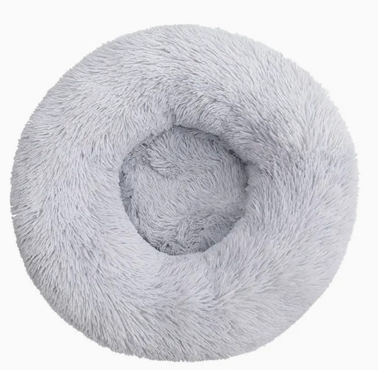Grijs donutvormig huisdierenbed met fluweelzachte stof, antislip bodem en wasbare hoes – ideaal voor knusse winterslaapjes.